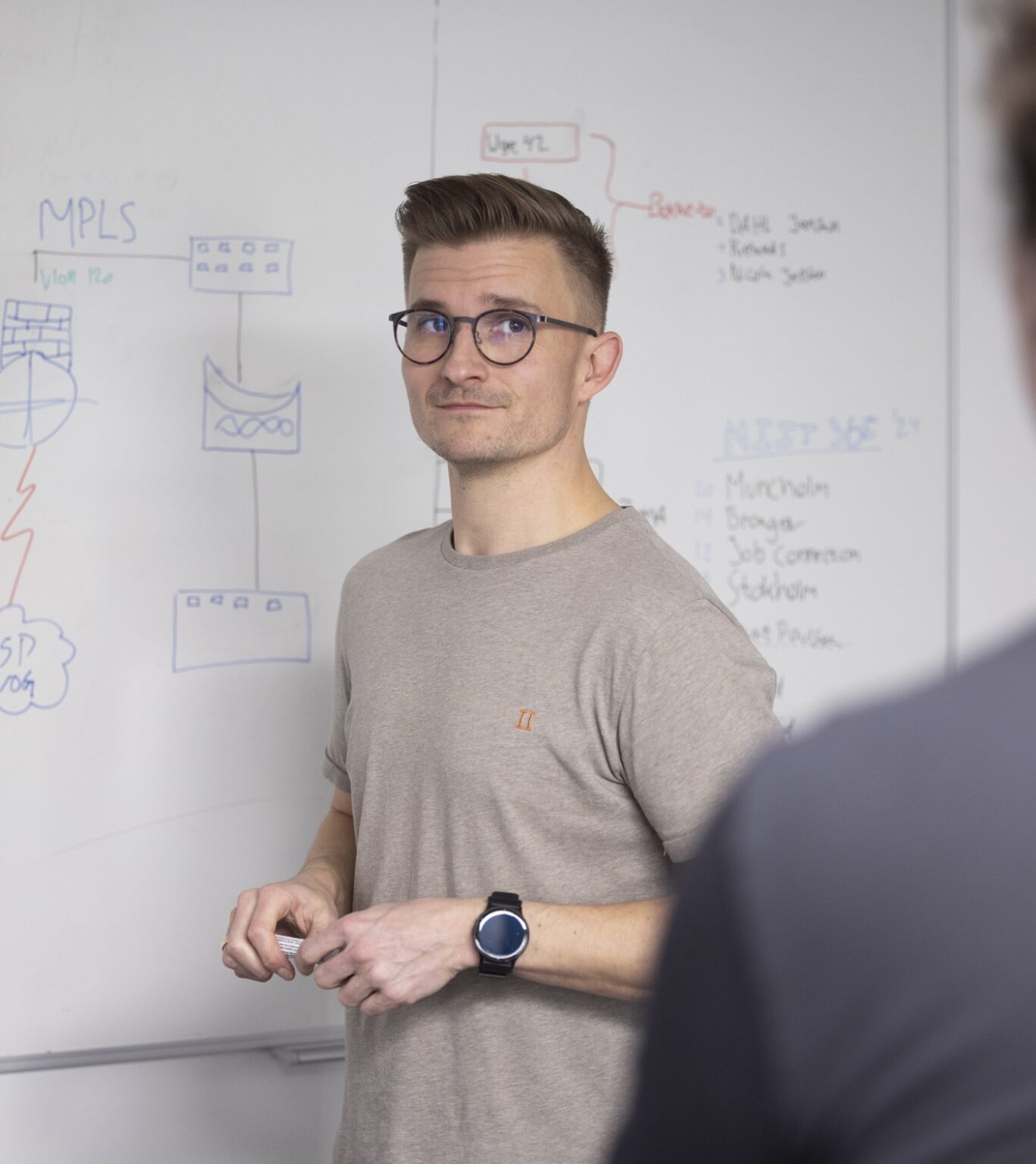 IT Konsulent designer IT løsninger til virksomheder foran tavle med netværks diagrammer